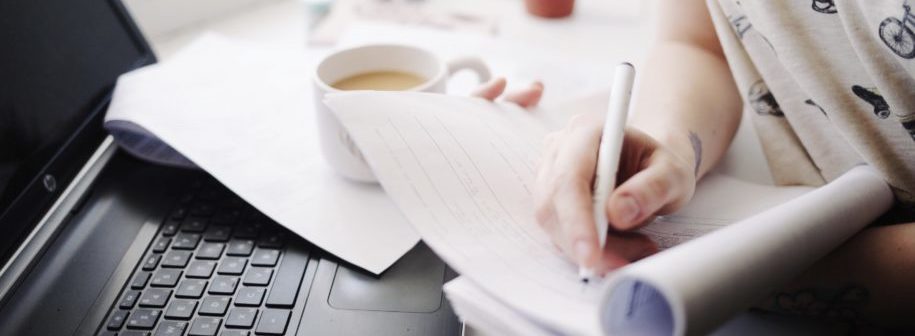 Person doing paperwork with a computer